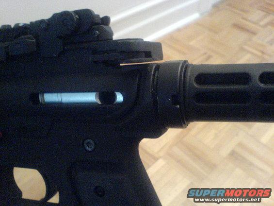 Close-up of a firearm receiver with a charging handle partially inserted