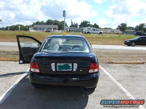 Black sedan rear view, driver door open. 2000 Nissan Sentra