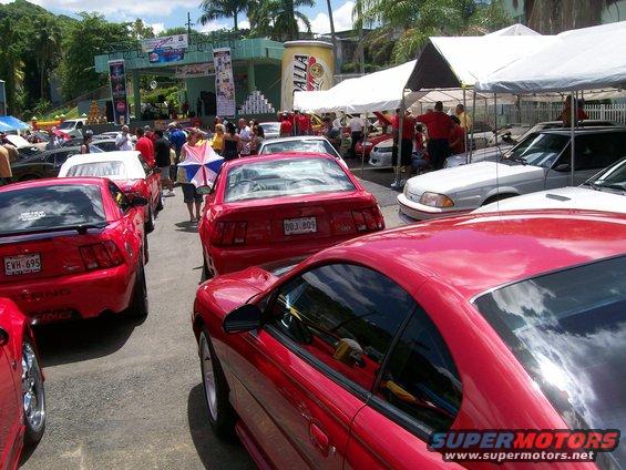 Red 2001 Ford Mustang coupe parked outdoors at a car show, viewed from the front three-quarter angle