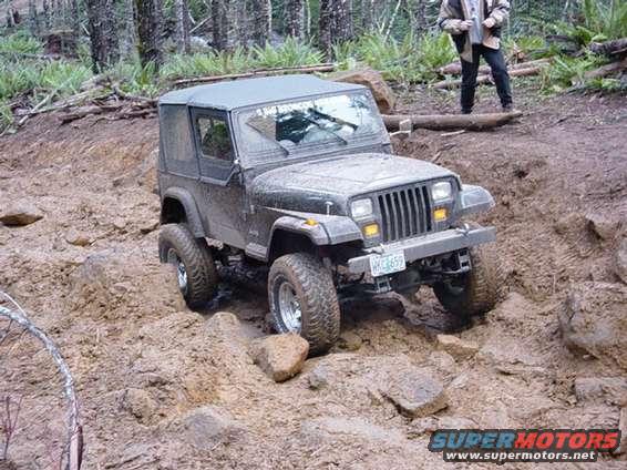 1995 Jeep Wrangler climbing a muddy hill, license plate WHC659