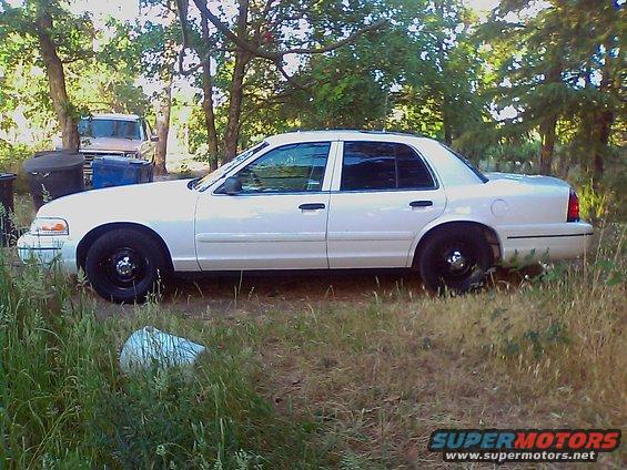2000 Ford Crown Victoria parked on grass, side view. Another vehicle is visible in the background