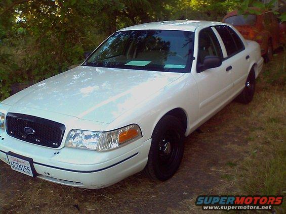 White 2000 Ford Crown Victoria, 3q-front view. Another vehicle is visible in the background