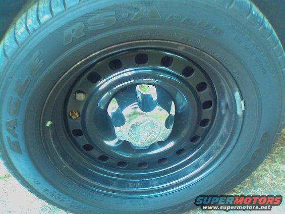 Close-up of a black steel wheel with a chrome hubcap and Eagle RS-A tire
