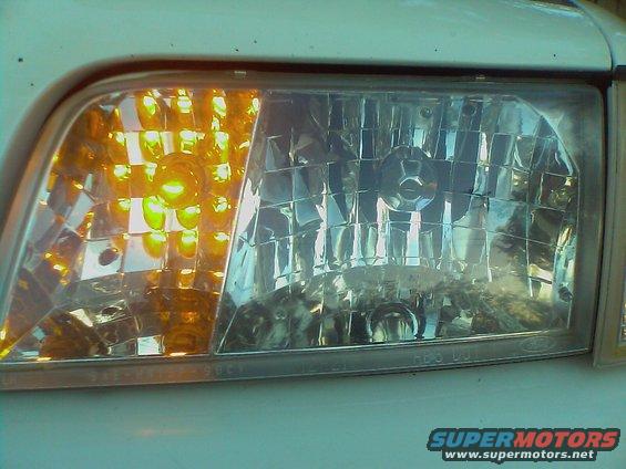 Close-up of a 2000 Ford Crown Victoria headlight assembly with amber turn signal