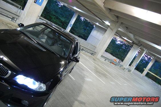 Black BMW M3 parked in a concrete parking garage