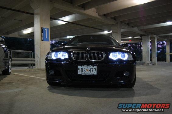 Black 2002 BMW M3 sedan with halo headlights parked in a garage