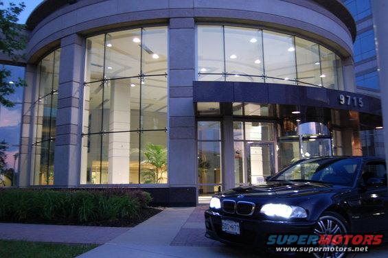 Black 2002 BMW M3 parked in front of a modern office building