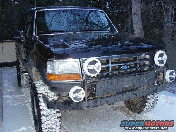 Black Ford Bronco with four auxiliary lights and snow on tires