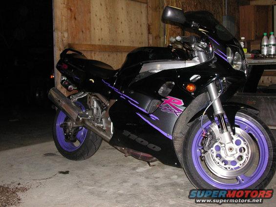 Black motorcycle with purple accents and wheels, side view