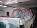 1996 Ford Bronco - A pickup truck is in a garage, undergoing body repair and preparation for a new paint job.