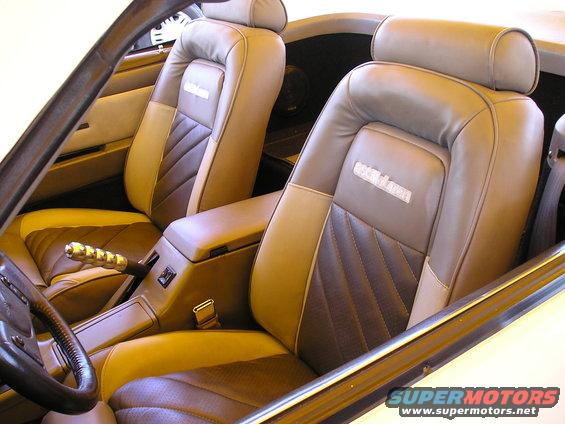 Car interior showing two-tone seats with diamond stitching and a chrome shifter