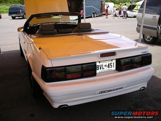 White convertible with black taillights and spoiler, rear view