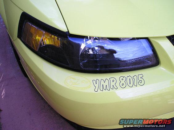 Yellow 2001 Ford Mustang front corner with headlight and YMR 8015 sticker