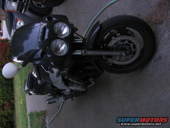 Black motorcycle front with dual headlights and black wheel