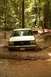 1987 Ford Bronco - A 1987 Ford Bronco navigates a muddy trail in a wooded area.
