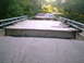 2001 Dodge 2500 - A bridge has been damaged, with debris and trees scattered around it.