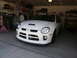 1996 Ford Probe - A white Dodge Neon SRT-4 is parked in a garage, showing its front end and hood scoop.