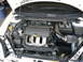1996 Ford Probe - The engine bay of a white car displays an SRT-4 engine cover and an aftermarket air intake system.