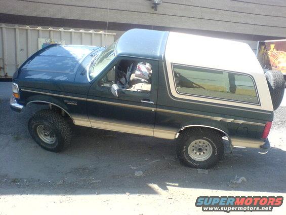 Green and tan Ford Bronco with a spare tire on the back