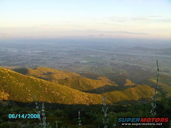 Hills and valley under a hazy sky, with a date stamp of 06/14/2008 and Supermotors logo