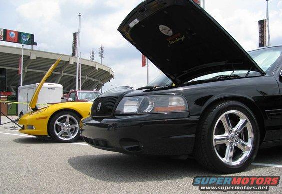 Black 2003 Mercury Marauder with hood open, front 3/4 view, parked next to a yellow car