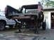 1979 Ford Bronco - The rear of a black truck is disassembled and elevated on jack stands, with a silver truck parked nearby.