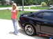 2003 Ford Mustang - A black 2003 Ford Mustang is shown from the side, chrome wheels and a rear spoiler.