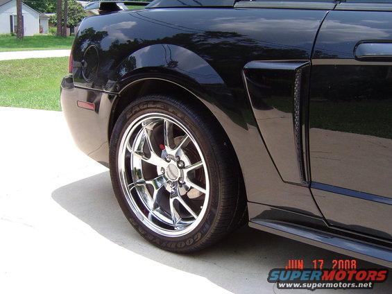 Black 2003 Ford Mustang rear quarter panel with chrome wheel and Goodyear tire