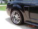 2003 Ford Mustang - Rear view of a black 2003 Ford Mustang showing the quarter panel and a chrome wheel.