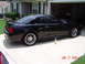 2003 Ford Mustang - A black 2003 Ford Mustang is parked outside a house with its garage open.