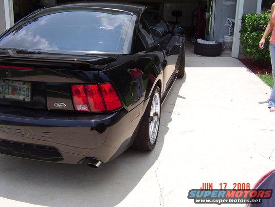 Rear quarter view of a black 2003 Ford Mustang parked in a driveway