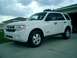 2008 Ford Escape - This white Ford Escape is parked in front of a garage on a cloudy day.