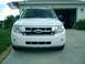 2008 Ford Escape - A white 2008 Ford Escape is parked in front of a garage with an American flag flying.