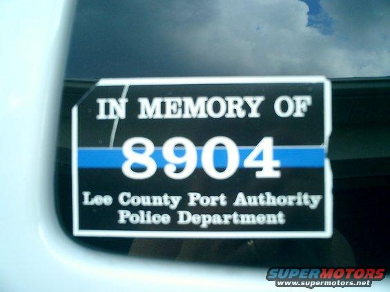 Decal on a white vehicle window reads 'IN MEMORY OF 8904 Lee County Port Authority Police Department'