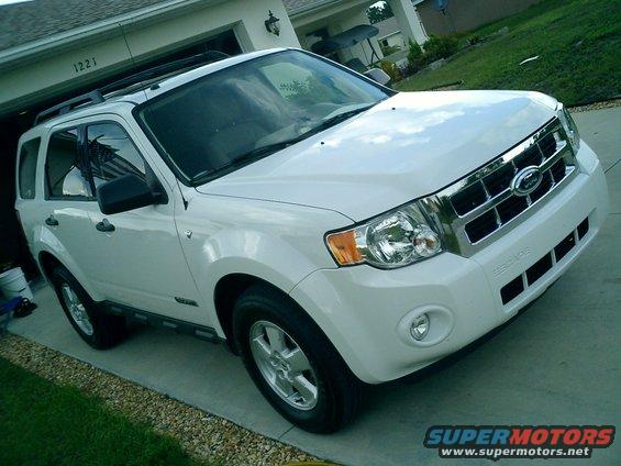 White 2008 Ford Escape parked in a driveway in front of a garage