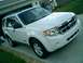2008 Ford Escape - The front end of a white 2008 Ford Escape is visible, parked in front of a residential garage.