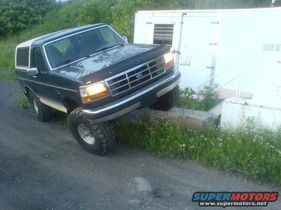 Dark blue and white Ford Bronco with lifted suspension