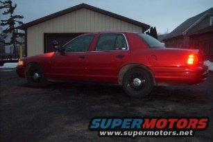 Red 2000 Ford Crown Victoria parked in driveway near garage