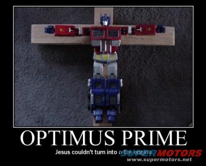Optimus Prime toy crucified on a wooden cross, with text "OPTIMUS PRIME" and "Jesus couldn't turn into a fire engine" below