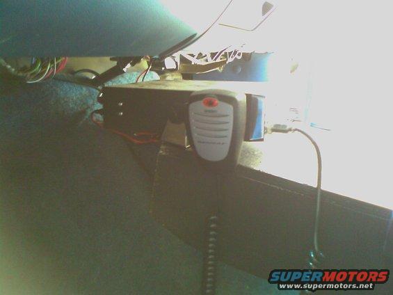CB radio mounted under dashboard with visible wiring and coiled cord