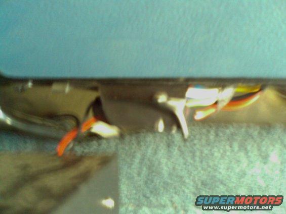 Wires and carpet inside a vehicle, with a Supermotors.net watermark