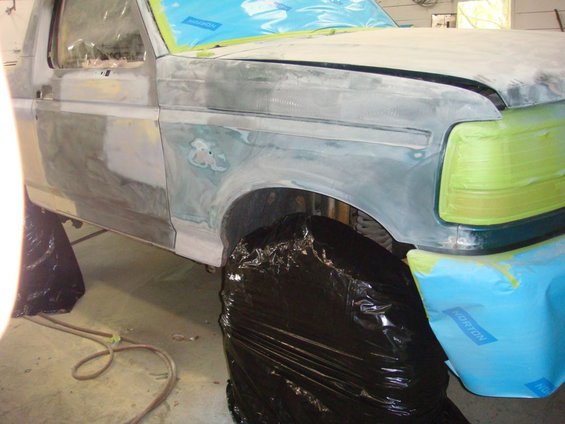 1996 Ford Bronco fender and door prepped for paint, covered in primer and masking tape