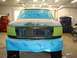 1996 Ford Bronco - A vehicle is prepped for body repair in a workshop, with masking tape and plastic covering the front end.