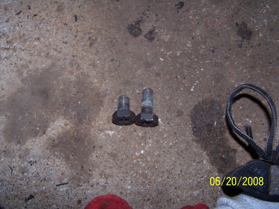 Two bolts on a concrete floor with a date stamp of 06/20/2008