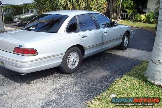 Silver sedan parked on driveway, another car in background