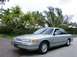1992 Ford Crown Victoria - This 1992 Ford Crown Victoria sedan is shown from a 3/4 front angle, parked outdoors with lush tropical foliage.
