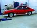 1990 Ford Mustang - A red and white 1990 Ford Mustang is parked in a garage with a grey hood and racing wheels.