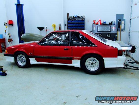 Red and white 1990 Ford Mustang drag car side view with 5.0 badge