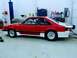 1990 Ford Mustang - Side profile of a red and white 1990 Ford Mustang drag car, a prominent '5.0' badge and racing slicks.