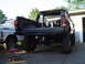 1979 Ford Bronco - A black Ford Bronco is parked next to a silver Ford truck, with its tailgate open and interior visible.